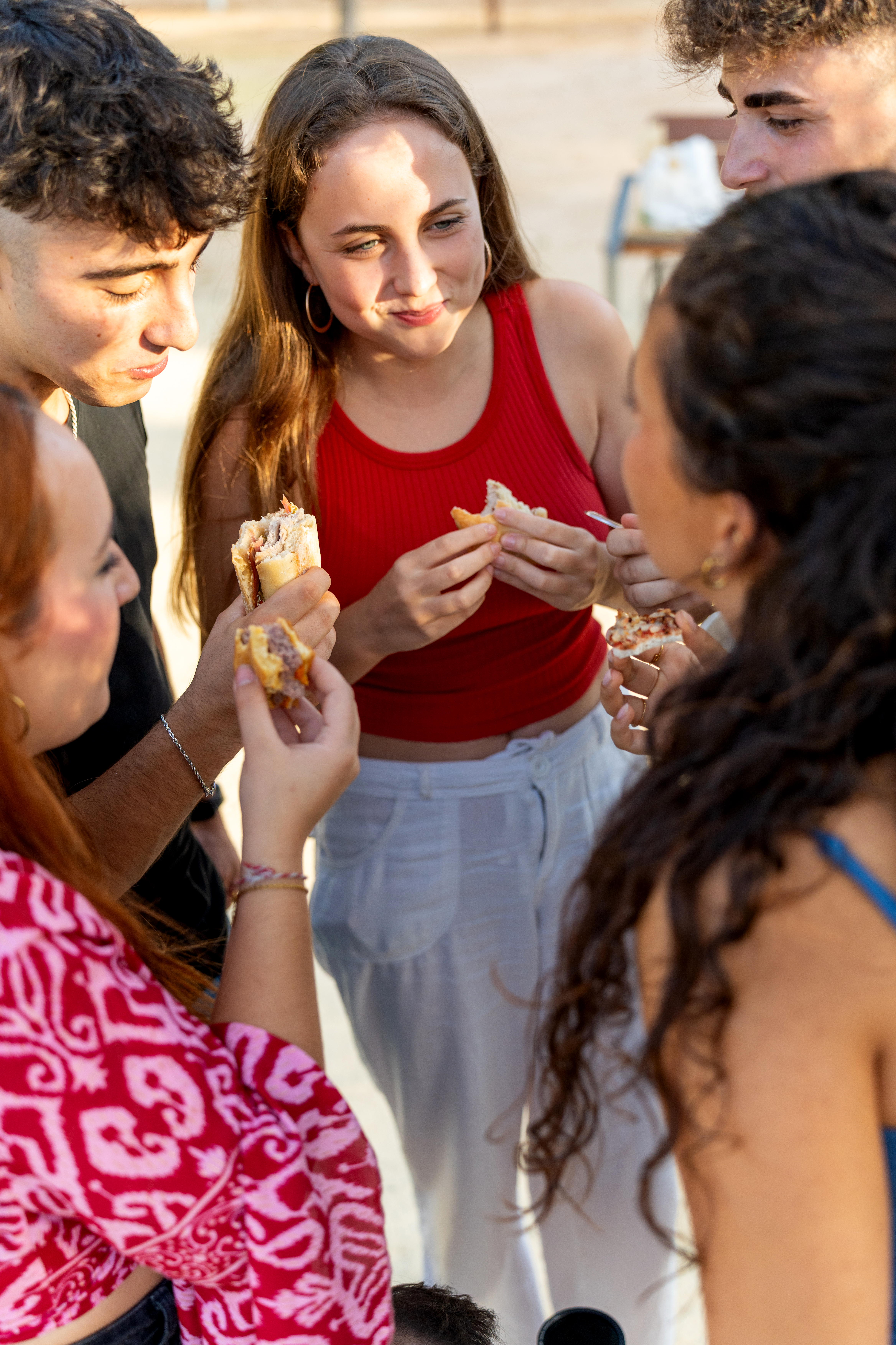 Young people sharing a meal outdoors, strengthening their bonds and enjoying each other's company